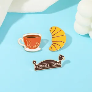Detail von Emaille-Pins mit Kaffeetasse, Croissant und Coffee & House Namensschild