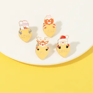 Detailed view of four Christmas enamel pins with snowmen and hearts on a white plate