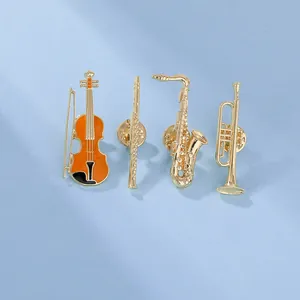 Close-up of music-themed gold enamel brooches with violin, sax, flute, and trumpet details