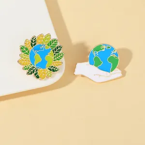 Dettaglio macro di spille in smalto Earth Day con motivi a girasole e mano su base chiara
