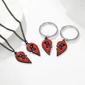 Dettaglio di ciondoli puzzle a cuore rosso e nero con motivi controller di gioco e catene