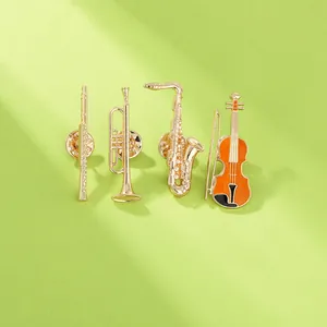 Detail of four golden musical instrument brooches on a light green background