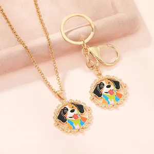 Detail of pet-themed gold necklace and keychain with colorful dog pendant on pink velvet