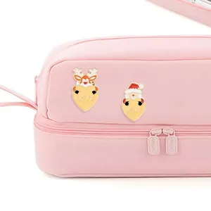 Close-up of Santa Claus and reindeer enamel pins with LOVE hearts on a pink bag