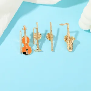 Detail shot of four golden musical instrument brooches with secure butterfly pin backings
