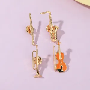 Detailed close-up of golden musical instrument enamel pins including saxophone and violin