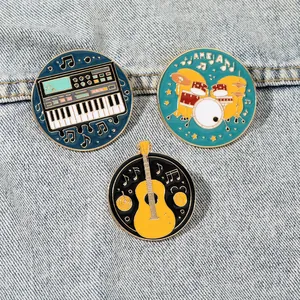 Set of three vintage musical instrument enamel pins on blue denim fabric background