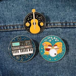 Detailed macro of enamel music brooches featuring guitar and drums on denim fabric
