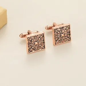 Détail de boutons de manchette carrés vintage avec motifs floraux en bronze et fermoir pivotant