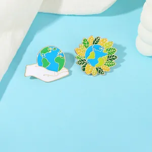 Dettaglio di spille in smalto Earth Day con mano che tiene la terra e design a girasole