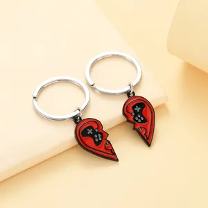 Dettaglio dei portachiavi a cuore con motivo di controller da gioco in smalto rosso
