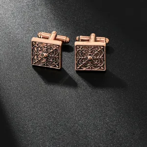 Détail macro de boutons de manchette carrés vintage avec motifs floraux sur fond noir
