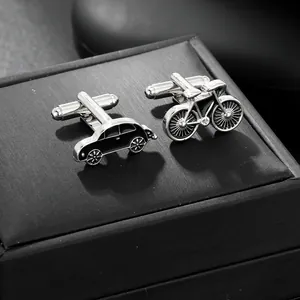 Detailed macro view of vintage car and bicycle shaped cufflinks on a textured jewelry box
