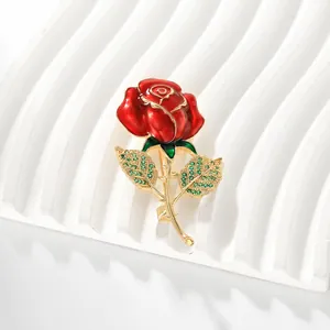 Macro de la broche rose 3D avec émail rouge, zircons verts et détails dorés dorés
