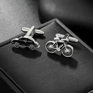 Close-up of vintage car and bicycle cufflinks on a textured black jewelry gift box