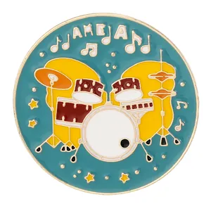 Round enamel brooch with drum set design and music notes on a bright blue background