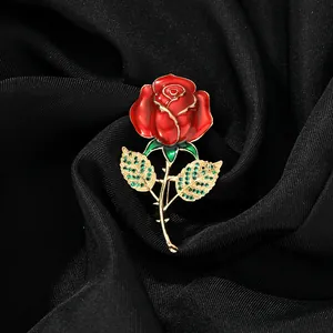 Gros plan détaillé d'une broche rose rouge avec cristaux verts sur soie noire