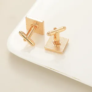 Macro detail of rose gold geometric square cufflinks with textured anti-slip backing
