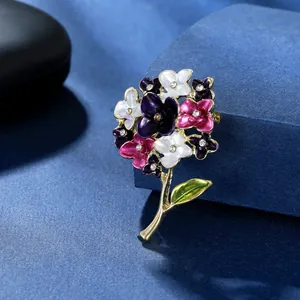 Dettaglio di un'elegante spilla a ortensia con petali in smalto colorato e strass lucidi