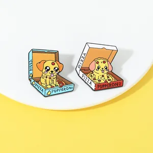 Detail of cute dog pizza enamel pins in blue and red boxes on a white plate background