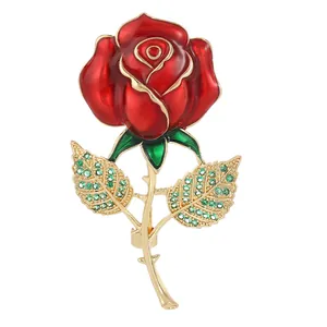 Élégante broche rose rouge avec pétales en émail et feuilles strass vert en fini doré