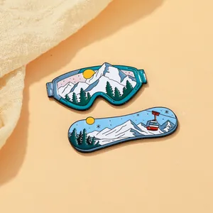 Dettaglio ravvicinato di spille smaltate a tema sci con montagne e maschere da sci