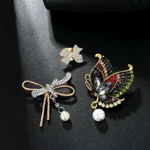 Close-up of luxury butterfly brooches with colorful rhinestones and hanging pearls
