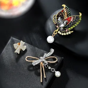 Detailed view of luxury butterfly brooches with multi-color crystals and pearl drops