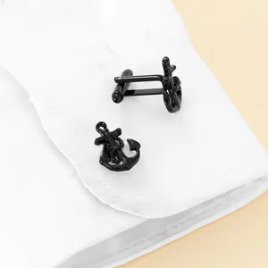Close-up of black anchor cufflinks styled on a white French shirt cuff for men