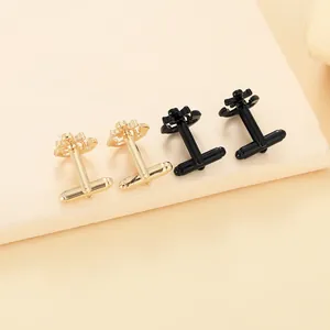 Macro shot of anchor-shaped cufflinks in gold and black finishes on a pedestal