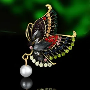 Macro detail of vintage butterfly brooch with colorful crystals and hanging white pearl