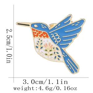 Colorful hummingbird enamel brooch with floral patterns and gold tone metal edges