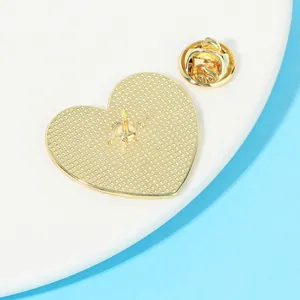 Golden heart-shaped metal brooch with a textured back and a secure butterfly clasp fastener