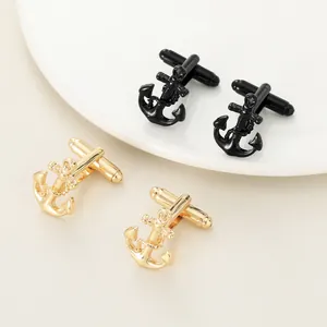 Polished anchor cufflinks for men in gold and black metal finish shown on a textured surface