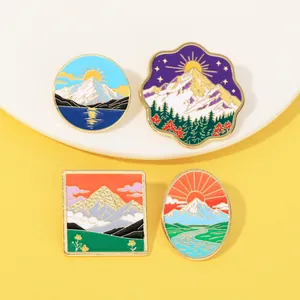 Détail de quatre pins en émail colorés avec paysages de montagne et vagues sur fond jaune