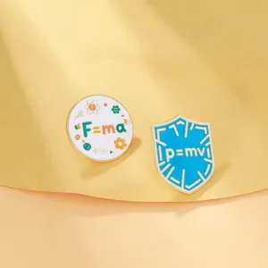 Detail of enamel pins featuring Newton's laws F=ma and p=mv physics formulas