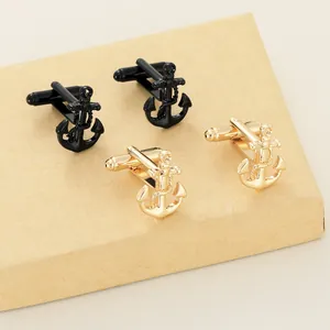 Detailed close-up of anchor-shaped cufflinks in matte black and polished gold finishes
