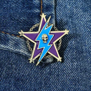 Macro shot of a purple star brooch with blue lightning and skull pinned on blue denim fabric