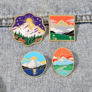 Lot de quatre épingles en émail représentant des paysages naturels sur du denim
