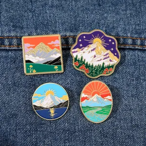 Détails de quatre pin's émaillés colorés aux motifs de nature sur fond de denim bleu