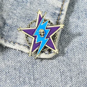Vintage gold star brooch with skull and lightning bolt detail on denim fabric