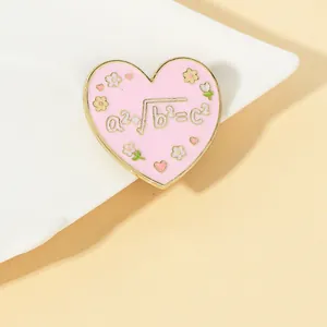 Detail of pink heart enamel brooch with math formula and white flowers on ceramic