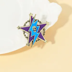 Gothic star and lightning enamel brooch with skull detail and gold chains on a white plate