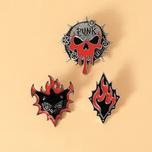 Lot de trois pin's punk en émail avec motifs de crâne, chauve-souris et flamme rouge et noir