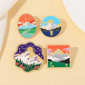Vue détaillée de quatre pin's en émail avec paysages de montagne et motifs naturels