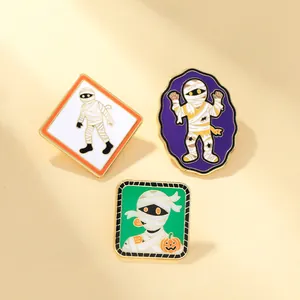 Tre spille smaltate mummia di Halloween con sfondi colorati per decorare borse e abbigliamento