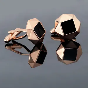 Macro-opname van roségouden manchetknoppen met zwart emaille en geometrische randen