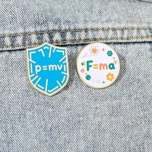 Physics enamel pins featuring p=mv and F=ma formulas on a denim jacket background