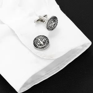 Detailed close-up of tree of life cufflinks on white shirt cuff with silver finish