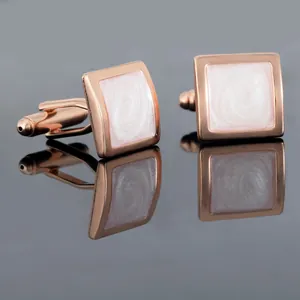 Détail de boutons de manchette carrés en or rose avec insert en nacre blanche